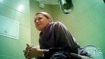 Взрослая женщина зашла в общественный туалет и не подозревая о скрытой камере стала справлять нужду